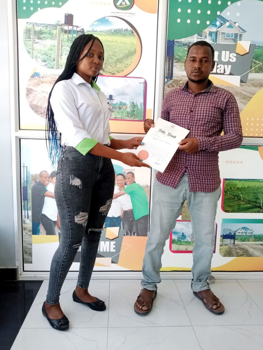 A happy client collecting his title deed